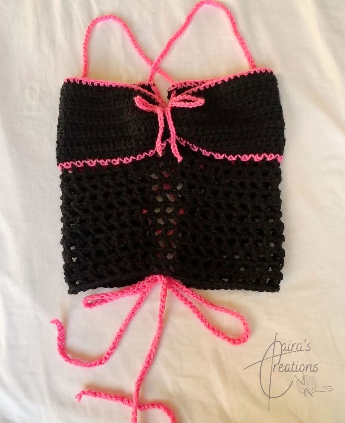 Black crochet halter top with hot pink trim and lace-up back